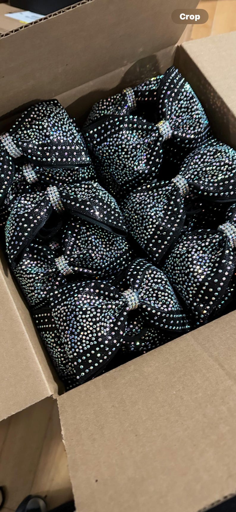 May include: A box filled with black fabric bows covered in iridescent rhinestones.