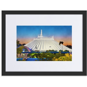 May include: A framed watercolour painting of Space Mountain at Walt Disney World. The white building is surrounded by green trees and a blue sky with a pink sunset.