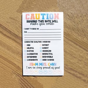 May include: A white note with a colorful border and the text "CAUTION READING THIS NOTE WILL make you smile". The note has a section for "I WANT TO BRAG ON:" and "FOR:" and a list of character qualities with checkboxes. The note ends with "FROM MRS. CONN I am so very proud of you" and a row of smiley faces.