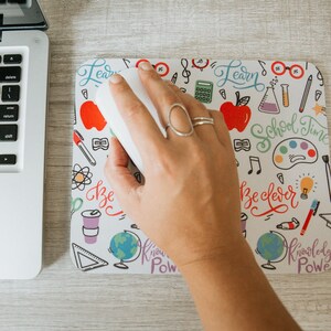May include: A white mouse pad with a colorful doodle design featuring school supplies, musical notes, and the words "Learn", "School Time", "Be Clever", "Knowledge Power", and "Know Power".