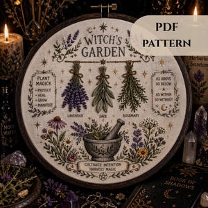 Puede incluir: Un bastidor de bordado redondo con un diseño de "Witch's Garden". El diseño incluye lavanda, salvia y romero bordados, junto con un mortero y una maja. El texto incluye "Plant Magick", "Cultivate Intention" y "Harvest Magic".