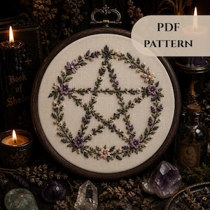 May include: A round embroidery hoop featuring a pentagram design, adorned with purple and cream-colored flowers and green leaves. The text "PDF PATTERN" is displayed on the top right. The hoop is set against a dark, mystical background.
