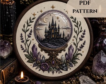 Puede incluir: Un bastidor de bordado con un panel de tela que muestra un diseño bordado de un castillo oscuro dentro de una bola de cristal, rodeado de cristales morados y ramas de lavanda. El texto PDF PATTERN aparece en la esquina superior derecha.