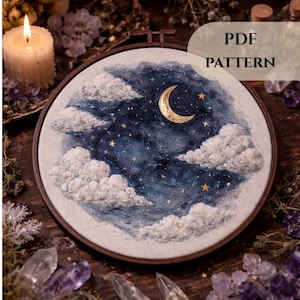 May include: A round embroidery hoop featuring a night sky scene with a crescent moon, stars, and fluffy clouds. The artwork is in shades of blue, white, and gold. The text "PDF PATTERN" is visible. The hoop is set against a dark wooden surface.