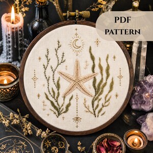 Puede incluir: Arte de aro bordado con una estrella de mar, algas marinas y elementos celestiales. El diseño incluye una luna creciente, estrellas y patrones geométricos en tonos neutros. El texto "PDF PATTERN" se muestra en la parte superior derecha.