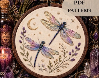 May include: Embroidered PDF pattern featuring two dragonflies with iridescent wings, a crescent moon, and stars. The design is set in a wooden embroidery hoop. The text "PDF PATTERN" is visible in the upper right corner. The overall theme is mystical and nature-inspired.