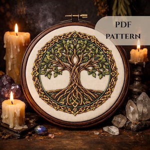 May include: A detailed cross-stitch pattern of a tree with intricate roots and branches, framed in a wooden hoop. The design features green leaves and a gold-colored border. The text "PDF PATTERN" is visible in the upper right corner. Lit candles and crystals surround the embroidery.