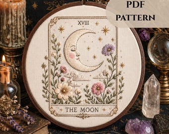 May include: Embroidered hoop art featuring a crescent moon with a serene face, surrounded by flowers and stars. The design includes the text "THE MOON" and "XVIII". The artwork is set against a cream-colored fabric, framed in a wooden hoop, and labeled "PDF PATTERN".