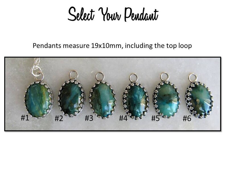 May include: Six oval-shaped pendants with a silver setting and green and blue gemstone. The pendants measure 19mm by 10mm, including the top loop. #1 #2 #3 #4 #5 #6