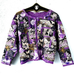 May include: A purple quilted jacket with a floral and butterfly print. The jacket has a button closure and long sleeves.