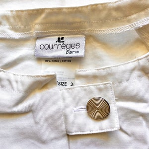 May include: White cotton pants with a Courr&egrave;ges Paris label and a gold button. The label says "100% Cotton / Cotton" and "Size 3".
