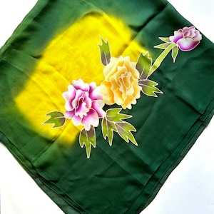 K&ouml;nnte beinhalten: Ein gr&uuml;ner Seidenschal mit einem gelben, orangen, rosa und wei&szlig;en Blumendesign. Der Schal hat einen Farbverlauf, der von Gelb zu Gr&uuml;n &uuml;bergeht.