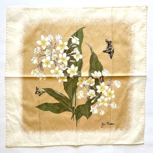 May include: Square silk scarf with a floral design featuring white and yellow flowers, green leaves, and black butterflies. The scarf has a cream-colored border and a tan center. The artist's signature, "Jim Thompson," is visible in the bottom right corner.