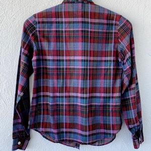May include: A long-sleeved plaid shirt with a button-down collar. The shirt is a mix of red, purple, blue, and green plaid.
