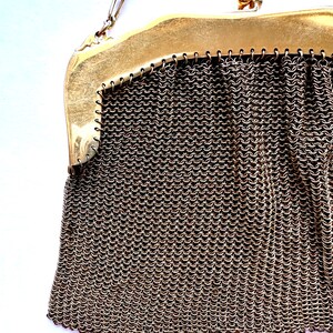Pu&ograve; includere: Una borsa a rete di catena dorata con chiusura a scatto. La borsa &egrave; realizzata con piccoli anelli di metallo collegati.