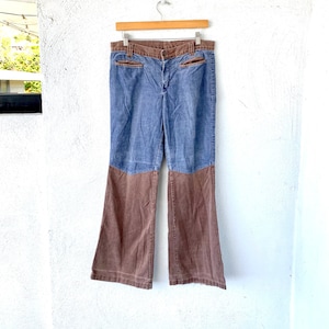 Könnte beinhalten: Blaue Jeans mit Glockenbeinen und braunen Cord-Einsätzen am unteren Bein.