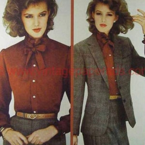 Pode incluir: Duas mulheres vestindo roupas semelhantes. A mulher &agrave; esquerda est&aacute; vestindo uma camisa de bot&otilde;es cor ferrugem com um grande la&ccedil;o e um cinto marrom. A mulher &agrave; direita est&aacute; vestindo um blazer cinza sobre uma camisa de bot&otilde;es cor ferrugem com um grande la&ccedil;o e um cinto marrom.