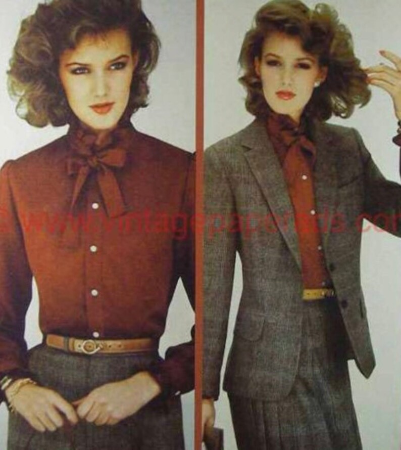Pode incluir: Duas mulheres vestindo roupas semelhantes. A mulher &agrave; esquerda est&aacute; vestindo uma camisa de bot&otilde;es cor ferrugem com um grande la&ccedil;o e um cinto marrom. A mulher &agrave; direita est&aacute; vestindo um blazer cinza sobre uma camisa de bot&otilde;es cor ferrugem com um grande la&ccedil;o e um cinto marrom.