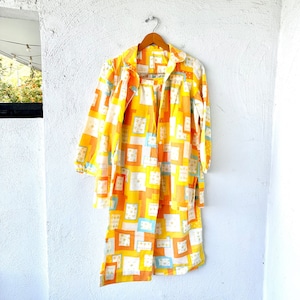 Op de afbeelding: Een gele en oranje pyjamaset met een geometrisch patroon. De set bestaat uit een shirt met lange mouwen en een broek.