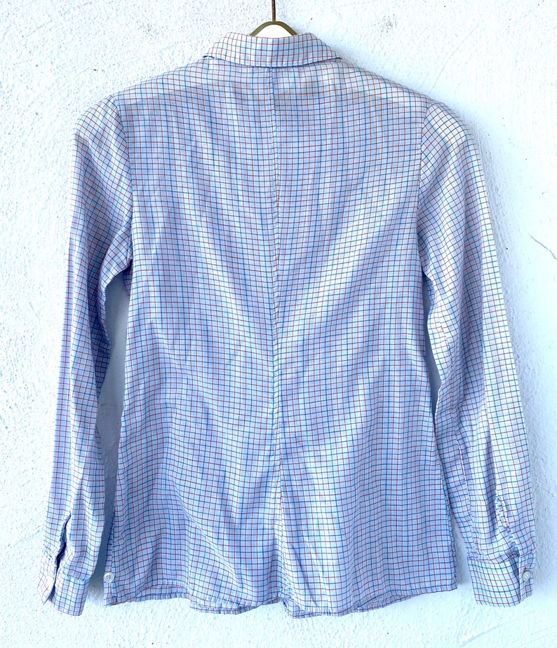 May include: A long-sleeved button-down shirt with a blue, white, and red plaid pattern.