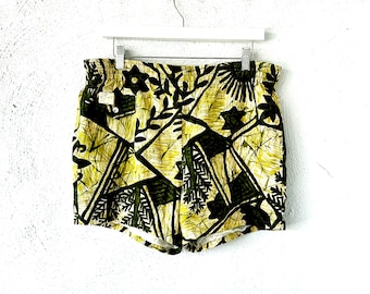 Peut inclure: Short de bain à motif vert et jaune avec un motif floral. Le short a une ceinture blanche et un cordon de serrage blanc.