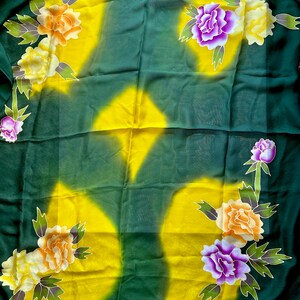 K&ouml;nnte beinhalten: Ein gr&uuml;ner und gelber Stoff mit einem Blumenmuster. Die Blumen sind lila, orange und gelb. Der Stoff ist durchsichtig und hat eine weiche, flie&szlig;ende Textur.