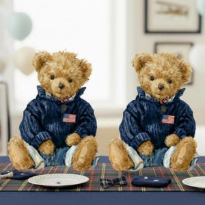 May include: Two teddy bears wearing blue sweaters with American flag patches and blue jeans sit on a table. The table is set with plates, a small shirt, shoes, and a rocking horse. The background includes balloons and framed artwork.
