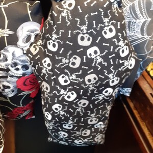 May include: Black fabric pillow with a white skeleton pattern. The skeletons are dancing and have bones scattered around them.