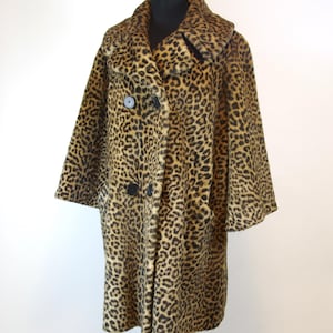 May include: A knee-length coat featuring a brown and black leopard print pattern. The coat has a wide collar, three-quarter length sleeves, and a double-breasted front closure with four large, round, black buttons arranged in two vertical rows.