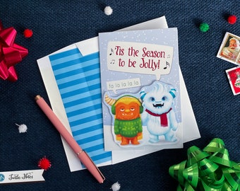 Tarjeta de felicitación navideña con monstruos cantando villancicos / ¡Es la época de la alegría! / Tarjeta festiva de temporada