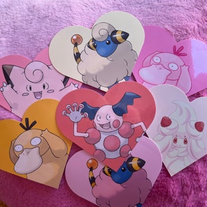 May include: A set of eight heart-shaped stickers featuring various Pokemon characters. The stickers are pink, yellow, and white with black outlines. The characters include a pink and white Eevee, a white and brown sheep-like Pokemon, a pink and white Pokemon with a large head, a white and pink Pokemon with a large head, a white and pink Pokemon with a large head, a white and pink Pokemon with a large head, a white and pink Pokemon with a large head, and a white and pink Pokemon with a large head.