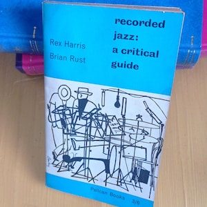 以下が含まれることがあります： レックス・ハリスとブライアン・ラスト著のペーパーバック『Recorded Jazz: A Critical Guide』。表紙は水色で、楽器とマイクを持つジャズバンドを描いた黒い線画が特徴です。ペリカン・ブックスから出版されています。