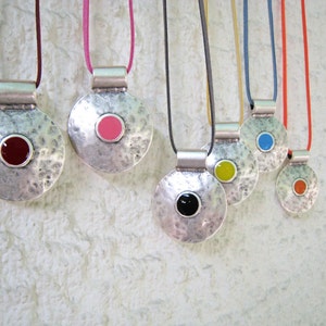 Big round pendant necklace, with a colroful resin detail and a slightly hammered surface. What color do you feel today?