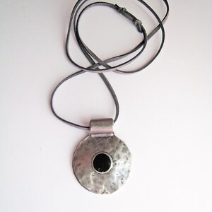 Big round pendant necklace, with an onyx black resin detail and a slightly hammered surface