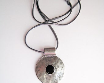 Big round pendant necklace, with an onyx black resin detail and a slightly hammered surface