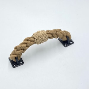 May include: A brown rope door handle with a knotted design and black metal mounting plates.