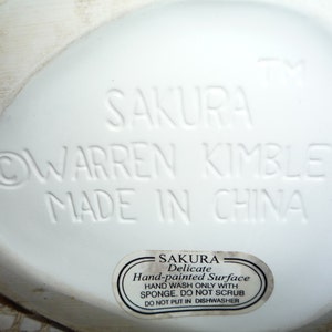 Peut inclure: Figurines en c&eacute;ramique blanche avec les mots "SAKURA WARREN KIMBLE MADE IN CHINA" au bas. Un autocollant sur la figurine indique "SAKURA Delicate Hand-painted Surface HAND WASH ONLY WITH SPONGE. DO NOT SCRUB DO NOT PUT IN DISHWASHER."