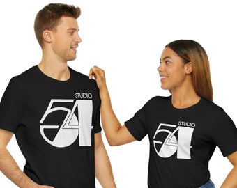 May include: Two people wearing black t-shirts with a white graphic of the text "Studio 54" on the front. The graphic is a stylized number 54 with a circle around it.