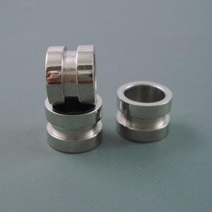 May include: Three silver metal rings stacked on top of each other. The rings are smooth and have a shiny finish.