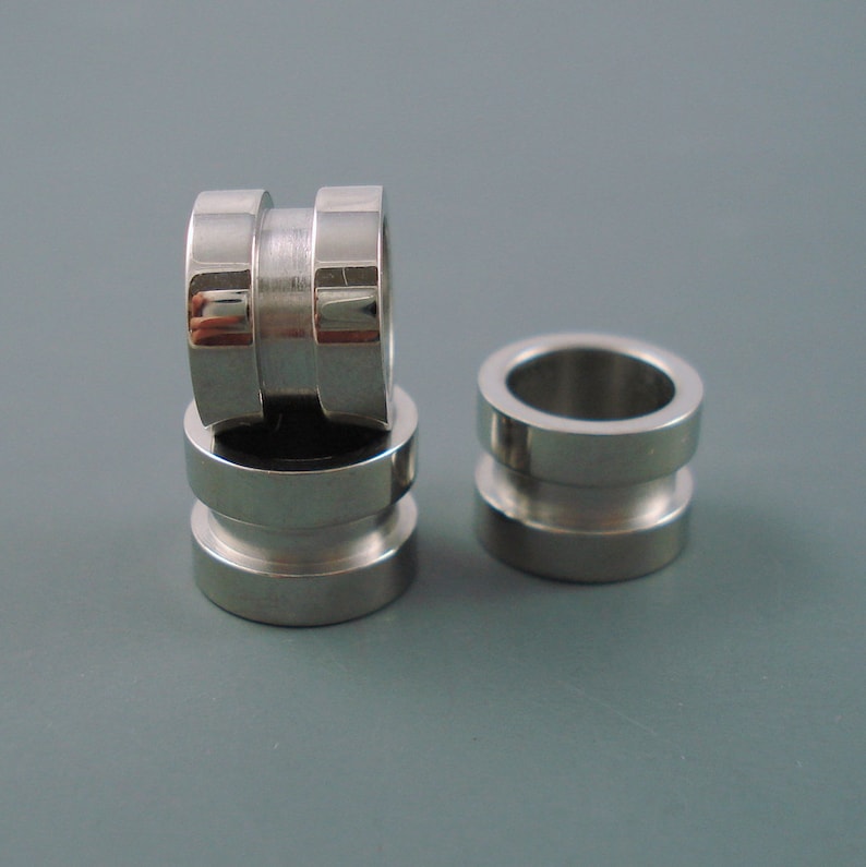 May include: Three silver metal rings stacked on top of each other. The rings are smooth and have a shiny finish.