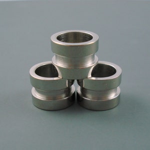 May include: Three silver metal rings stacked on top of each other. The rings are smooth and have a shiny finish.