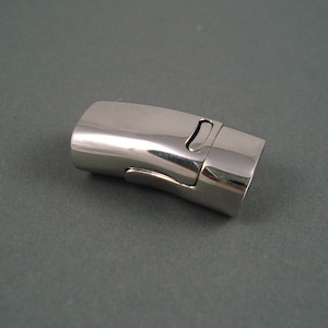 May include: A silver-toned magnetic clasp for jewelry making. The clasp is curved and has a smooth, polished finish.