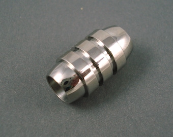 May include: A silver metal bead with a cylindrical shape and a smooth, polished finish. The bead is made up of multiple rings stacked on top of each other, creating a layered effect.