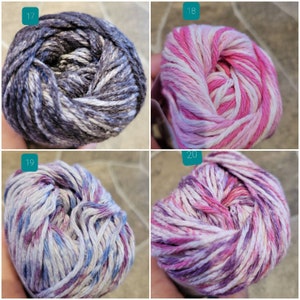 May include: Four skeins of yarn in different color combinations. The yarn is a variegated blend of white, pink, purple, and gray.