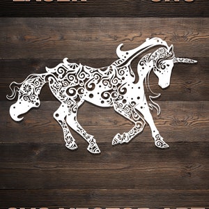 Może przedstawiać: Biała sylwetka jednorożca z misternymi, wirującymi wzorami na ciele. Jednorożec jest zwrócony w prawo i ma długą, falującą grzywę i ogon. Obraz jest umieszczony na tle imitującym drewno z tekstem "LASER CNC SVG VECTOR ART" u góry i na dole.