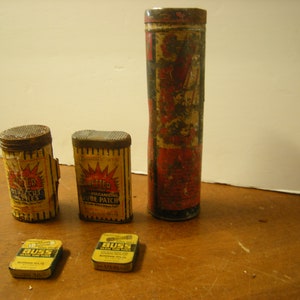 May include: Four vintage metal tins with yellow and red labels. The tins contain "Better Vulcanizing Tube Patch" and "Better Vulcanizing Patches". Two smaller tins contain "Buss Glass Tube Plugs".