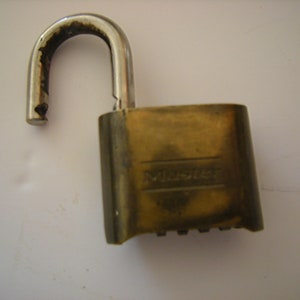 May include: A brass combination padlock with a silver shackle. The padlock has the word "Master" embossed on the front.