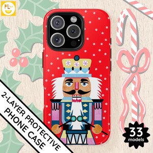 May include: Red phone case with a Nutcracker design. The Nutcracker is wearing a blue and red suit with a white beard and a red hat. The case has a white polka dot pattern.