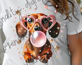 May include: A white t-shirt with a graphic of a dachshund wearing pink heart-shaped sunglasses and blowing a bubble. The background is a white and gold glitter pattern.