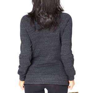 May include: Dark gray long-sleeve sweatshirt with a crew neck. The sweatshirt has a heathered texture and fitted sleeves. The model is wearing black leggings. The Vintage Fly logo is visible in the bottom right corner.